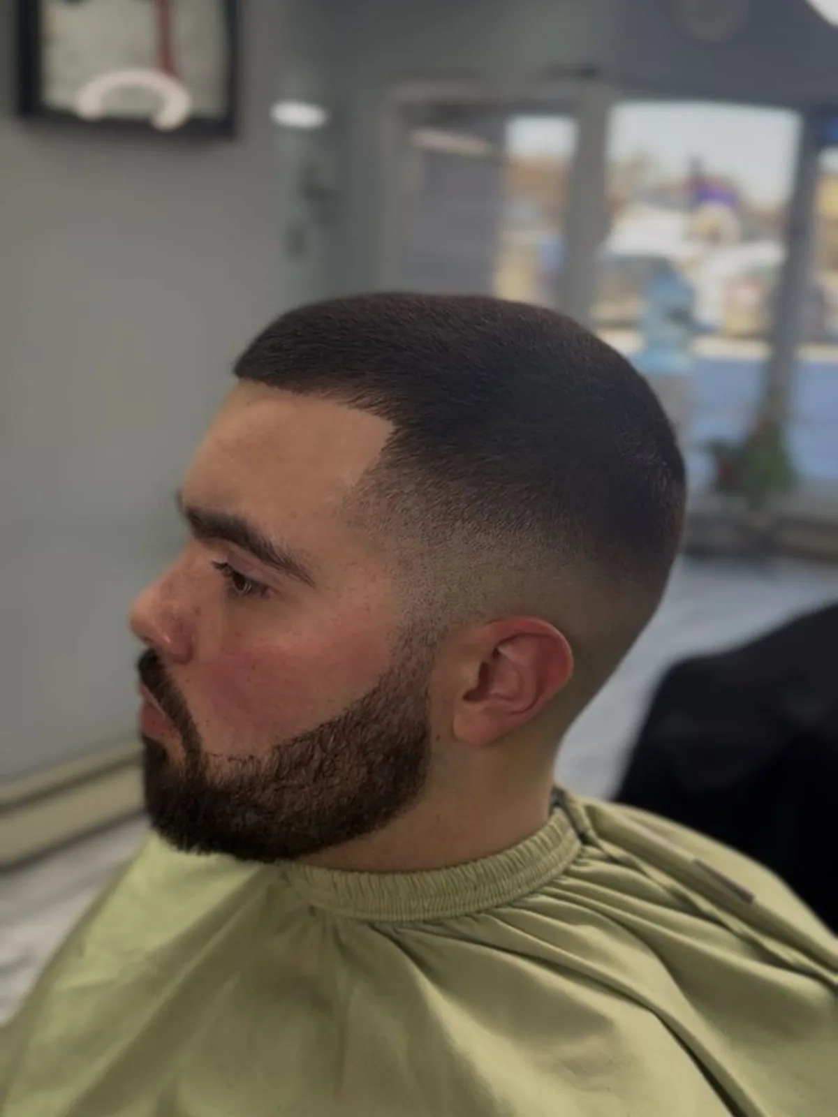 Buzz cut with a skin fade, sharp lineup and boxed beard