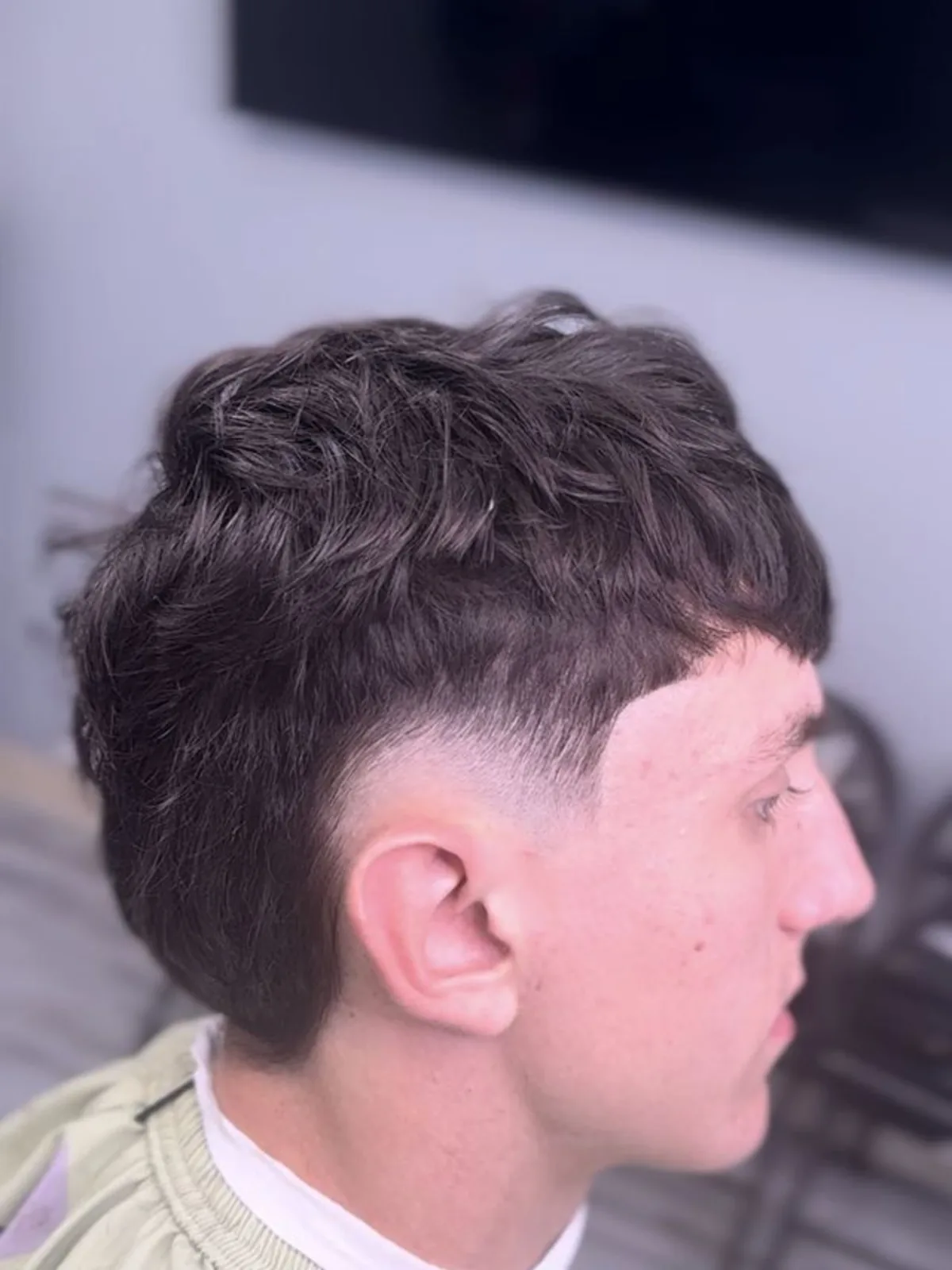 Dark wavy modern mullet with a burst fade