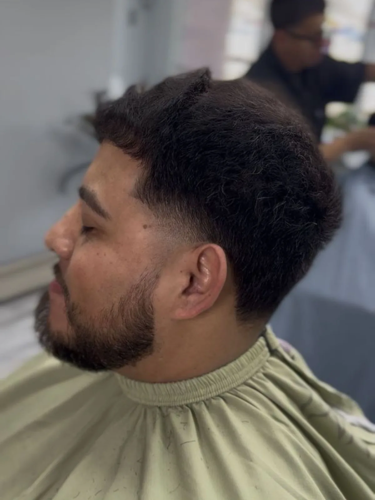 Black textured fringe with a low taper and full beard