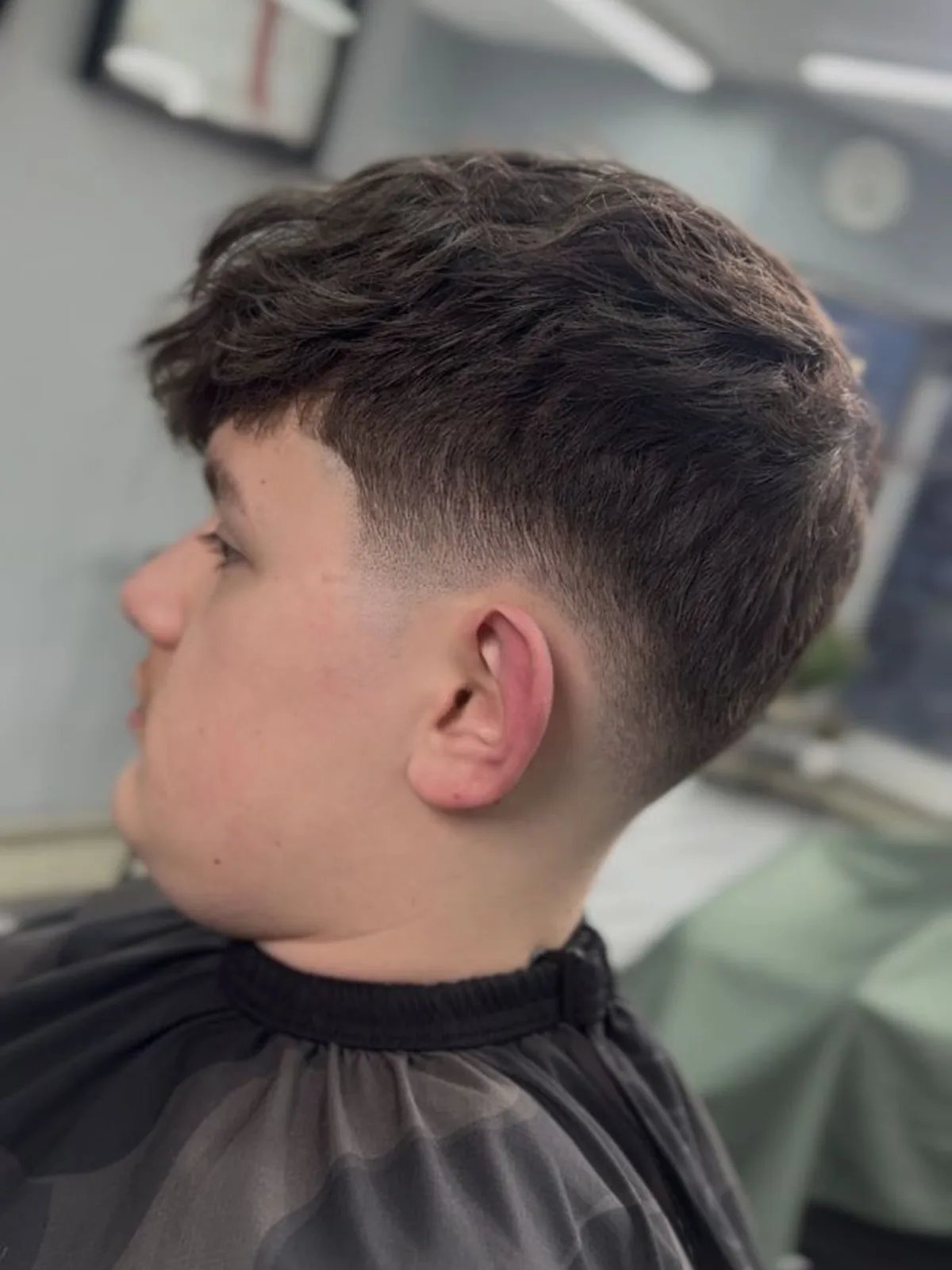 Textured fringe haircut with a low taper fade
