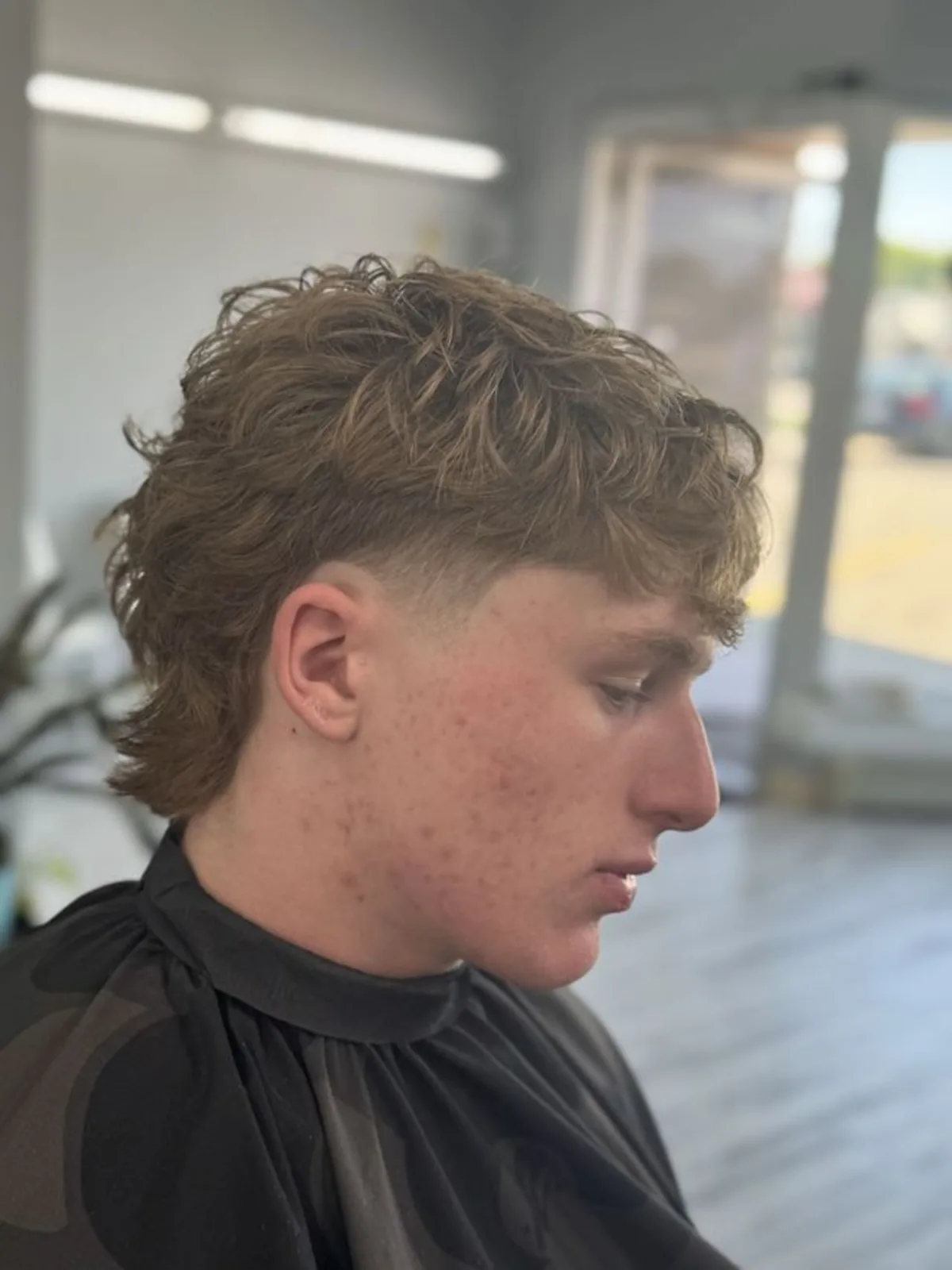 Wavy light brown mullet with a burst fade