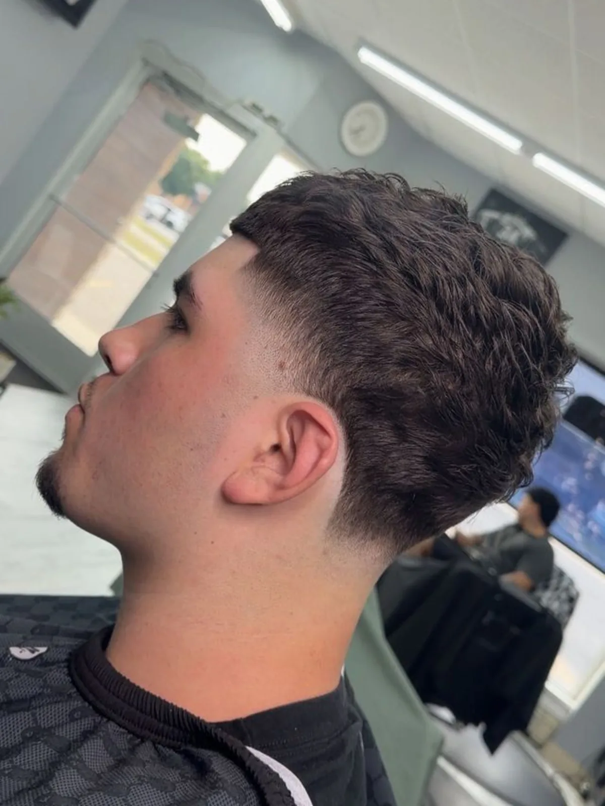 Curly textured fringe with a burst taper fade