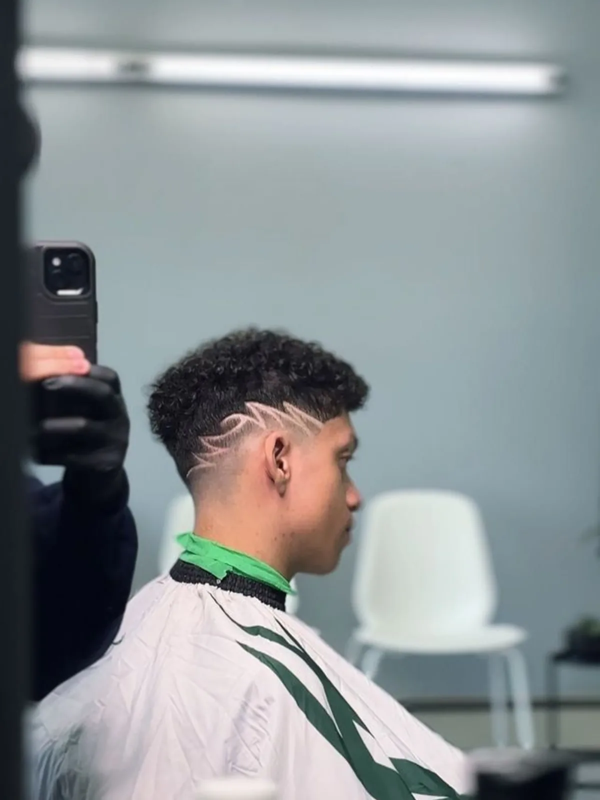Curly top with a taper fade and freestyle line design