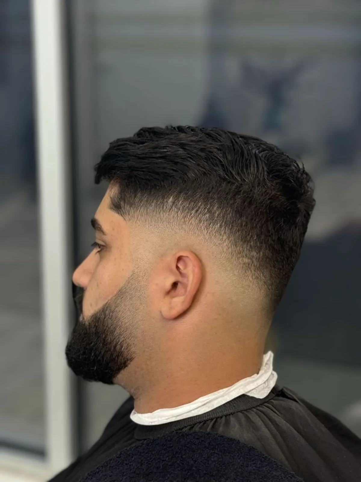 Brushed-up crop with a low fade and full beard
