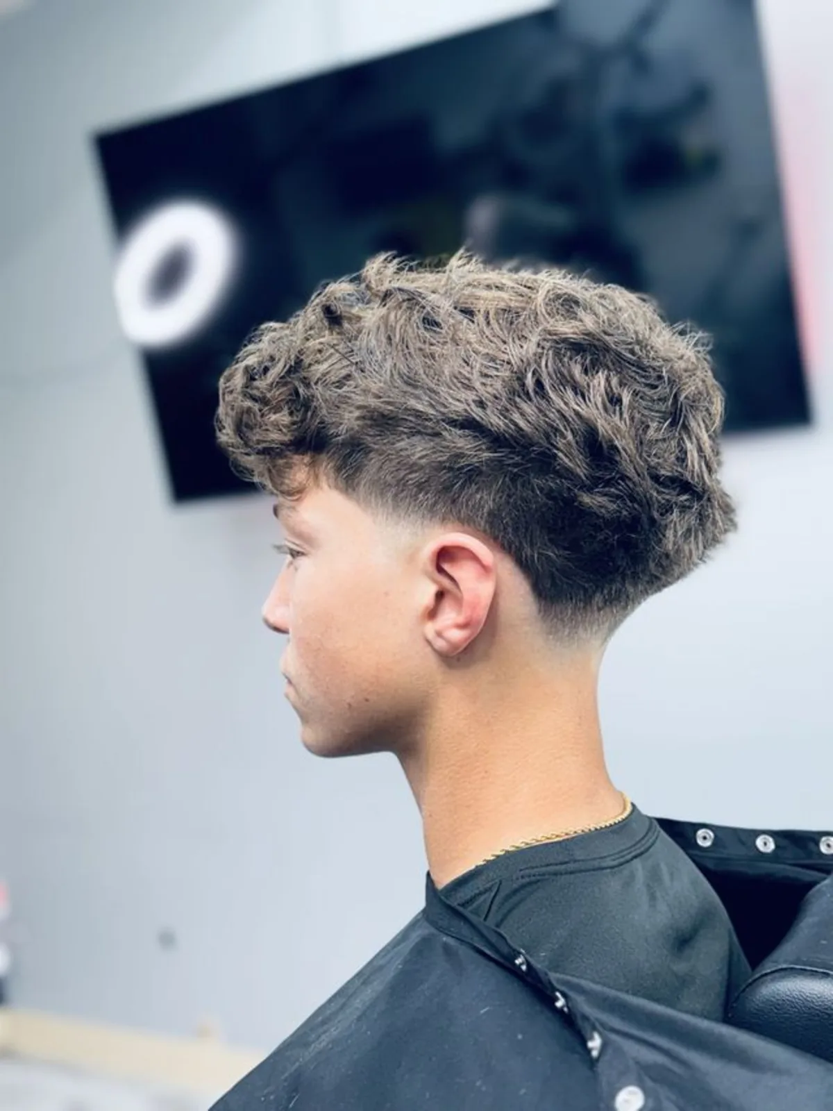 Curly textured fringe with a low taper fade