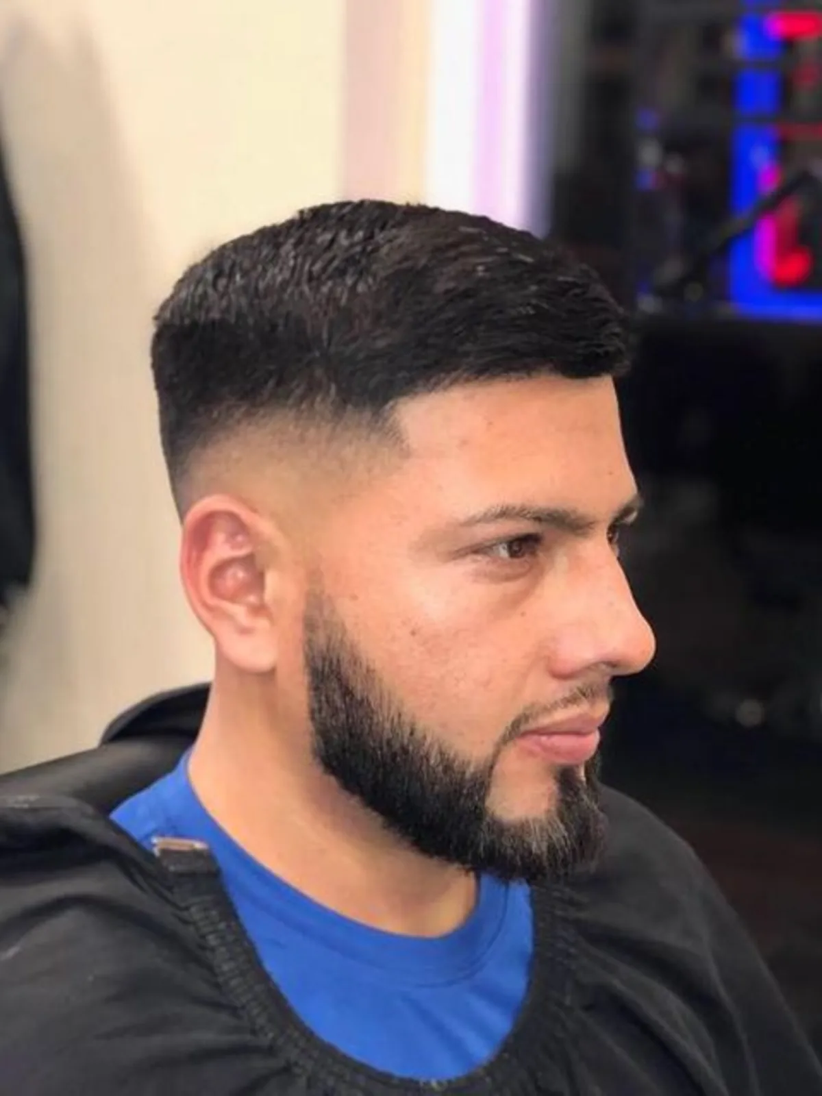 Short textured crop with a mid fade and lined beard