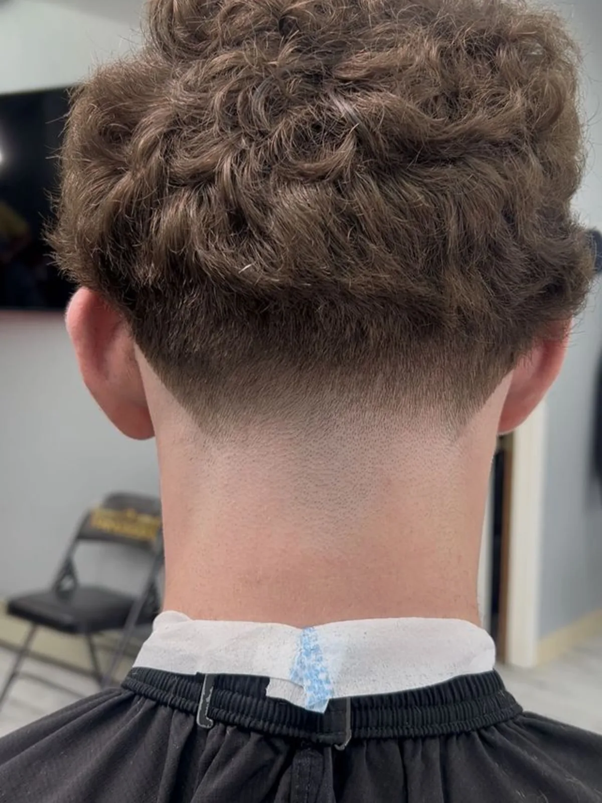 Curly top with a low taper neckline, back view